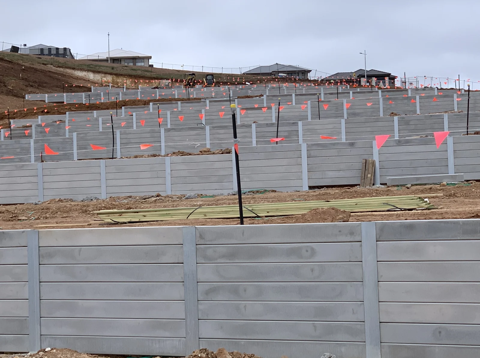Stepped concrete sleeper retaining walls and steel posts at Queensbrook Estate